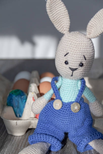 istock The Easter Bunny is on a wooden surface with painted eggs. 1371320601