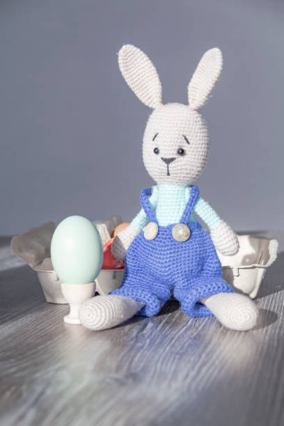 istock The Easter Bunny is on a wooden surface with painted eggs. 1371320630