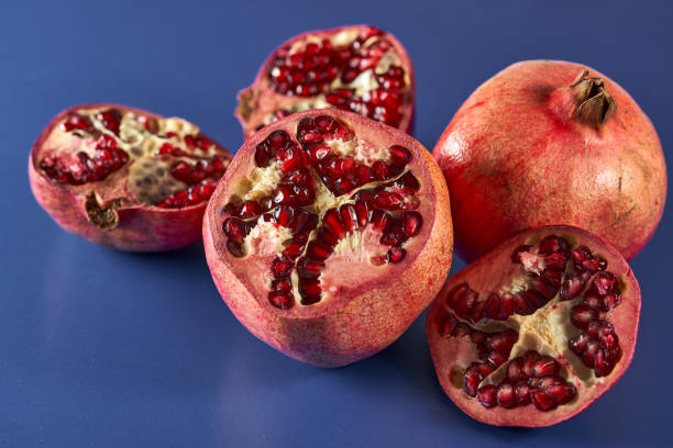 istock Sliced pomegranate on blue background 1371320658