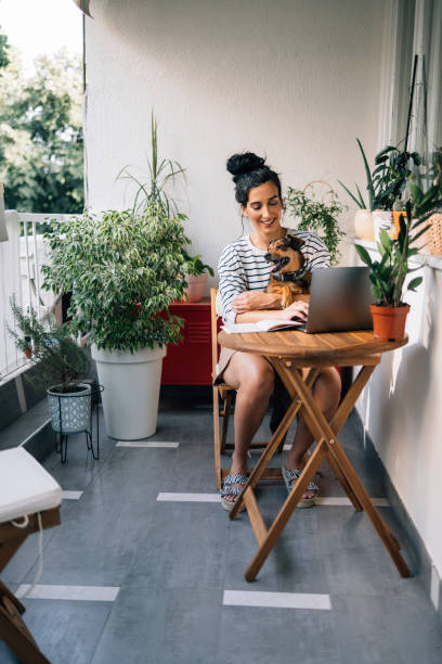 istock Beautiful Smiling Woman Working from Home while Her Dog is Sitting on Her Lap 1371322977