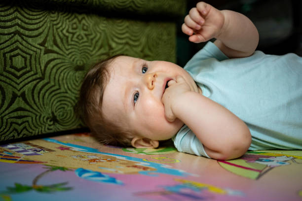 A 6 month old baby boy smiling as he chills in a chair.