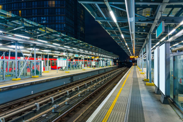 plataforma ferroviária de docklands light à noite - canary wharf railway station - fotografias e filmes do acervo