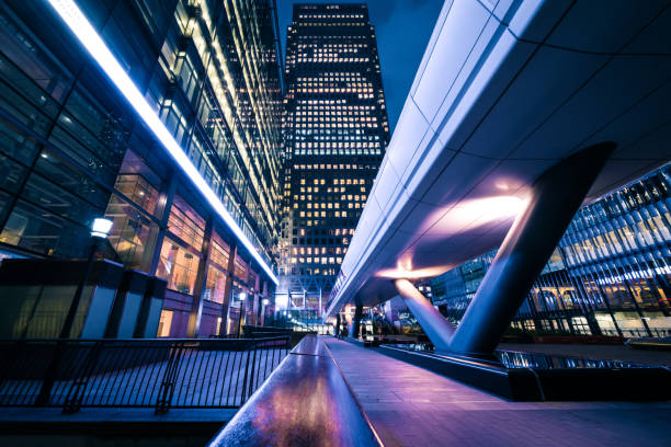 leuchtende bürogebäude in canary wharf, london at night - architecture bridge built structure business stock-fotos und bilder