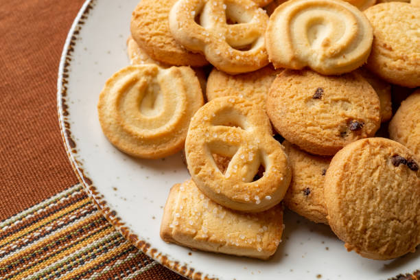 istock Danish butter cookies on a white plate. Heap of assorted crispy shortbread biscuits close-up. Baked pastry for breakfast. Tasty snack. Sweet food, dessert and calories concepts. 1371327930