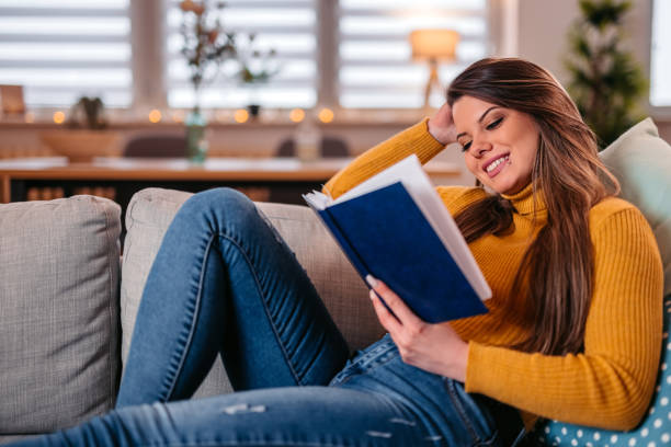 istock Young Woman Lying On The Sofa And Reading A Book 1371331835