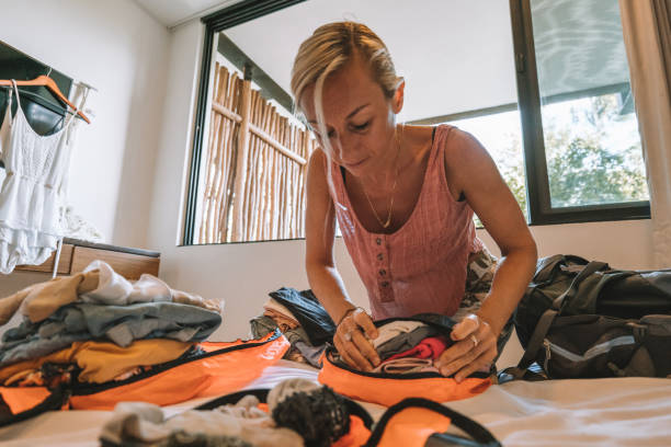 istock Young woman packing clothes in a backpack 1371334457