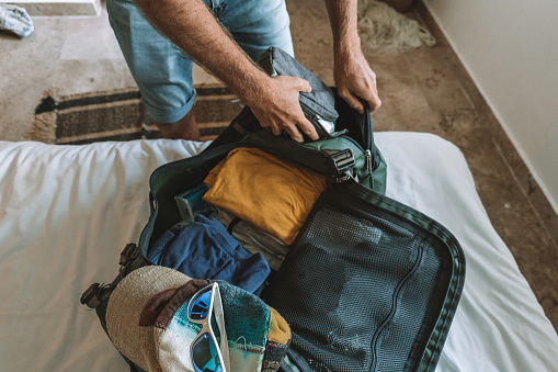 He packs his clothing neat and organised in a bag.
People travel preparation concept. Vacation or working abroad.