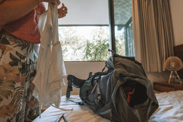 istock Young woman packing clothes in a backpack, unrecognisable person 1371334491