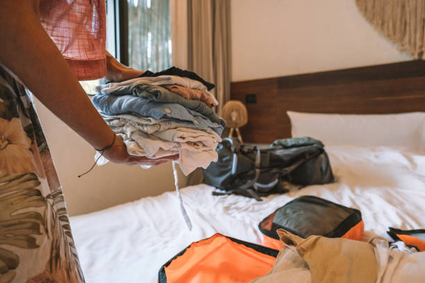 istock Young woman packing clothes in a backpack, unrecognisable person 1371334633