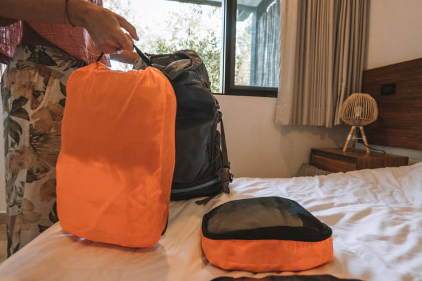 istock Young woman packing clothes in a backpack, unrecognisable person 1371334777