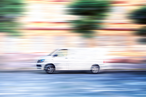 White van speeding down a city street.
