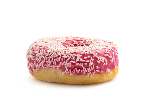 Pink donut with white sprinkles isolated on white background.