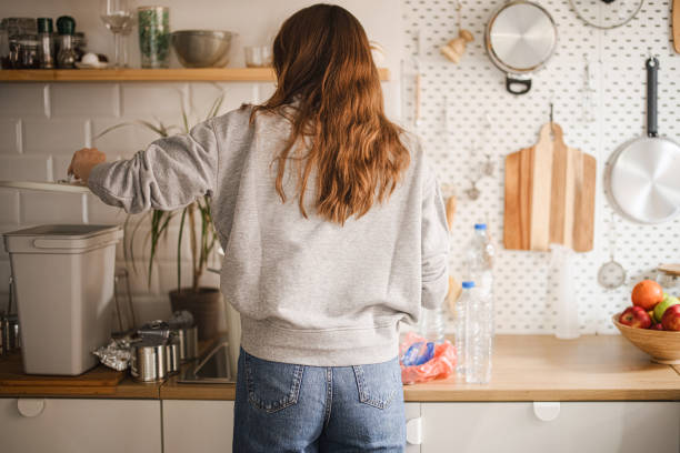 istock Woman recycling plastic waste at home 1371338904