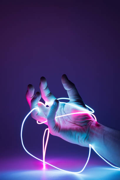 istock Hand tied with neon led cables on a dark background. 1371339120