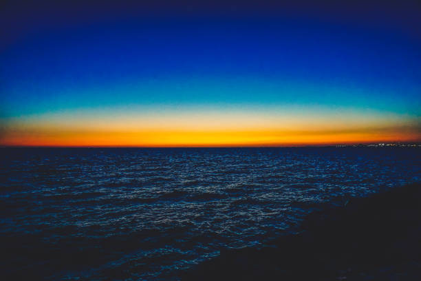 The Ocean in Australia on the stony shore in setting sun. stock photo