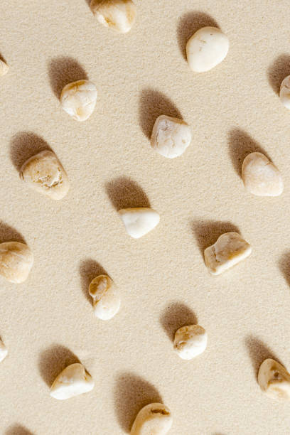 istock Aesthetic minimal pattern with set of pebble stones on fine sand background. Top view on natural stone neutral beige color. Summer concept 1371341626