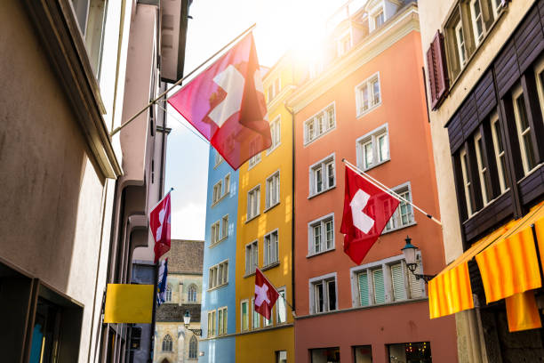 Beautiful Idyllic Street With Architecture And Flags In Geneva, Switzerland