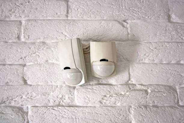 istock Sensors of the security system. Mounted on an old brick wall painted white. 1371343939