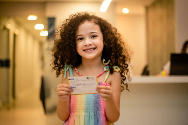 Smiling small child shows vaccination card.
