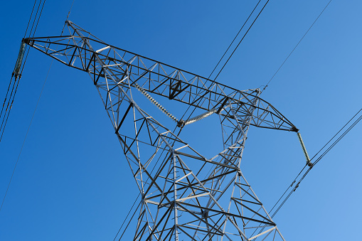 Close-up of electrical pylons with blue skies