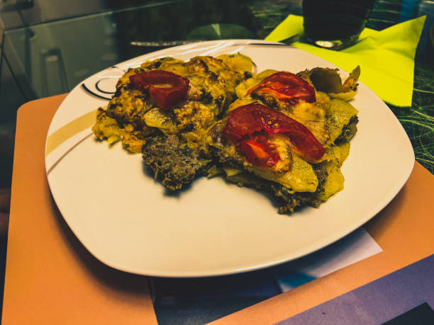 Oven potatoes with meat tomatoes and cheese gratinated.