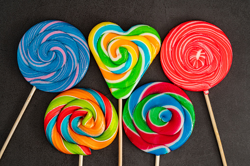 Colorful candies, lollypop on black background, multicolored candies.
