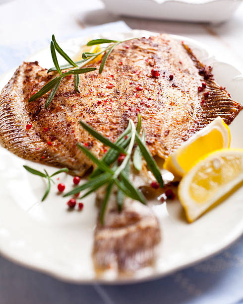 Pan fried turbot with rosemary and lemons pan fried turbot flavored with rosemary, pink pepper and lemon turbot stock pictures, royalty-free photos & images