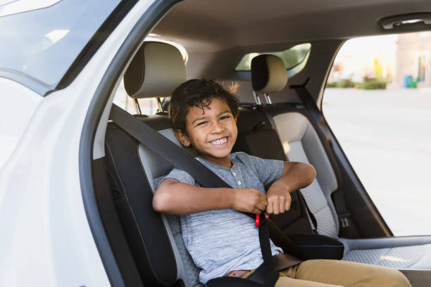 istock Elementary age boy buckled into booster seat smiles for camera 1371356367