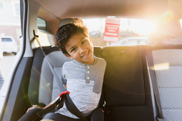 istock Silly elementary age boy plays in car booster seat 1371356412