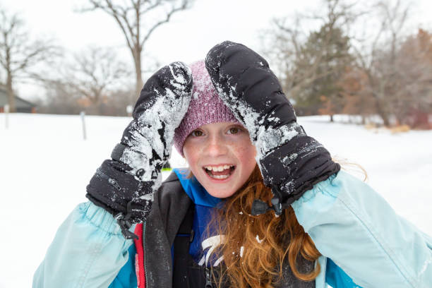 Girl Playing in Snow on Winter Day stock photo