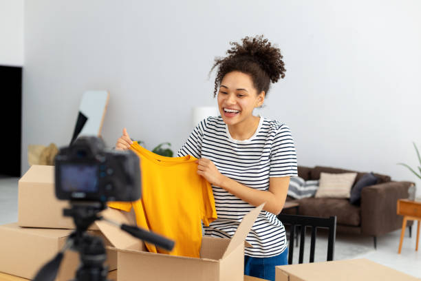 istock African American female vlogger freelancer using camera to recording video content makes review of products ordered online Woman owner of online clothing store shoots an advertisement for her product 1371356795