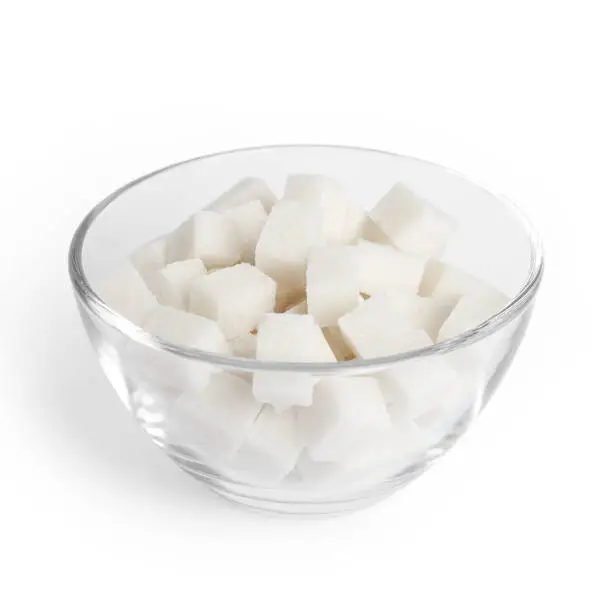 Sugar cubes in glass bowl isolated on white background