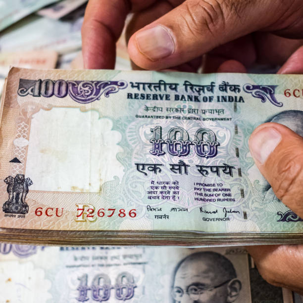 istock Old One Hundred Rupee notes combined on the table, India money on the rotating table. Old Indian Currency notes on a rotating table, Indian Currency on the table 1371359495