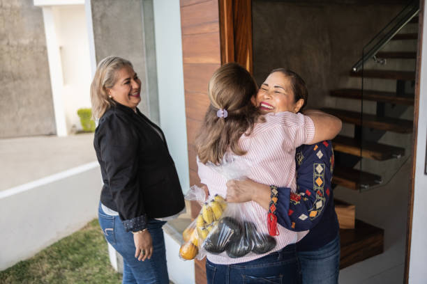 Mature Latin woman welcoming friends at home stock photo