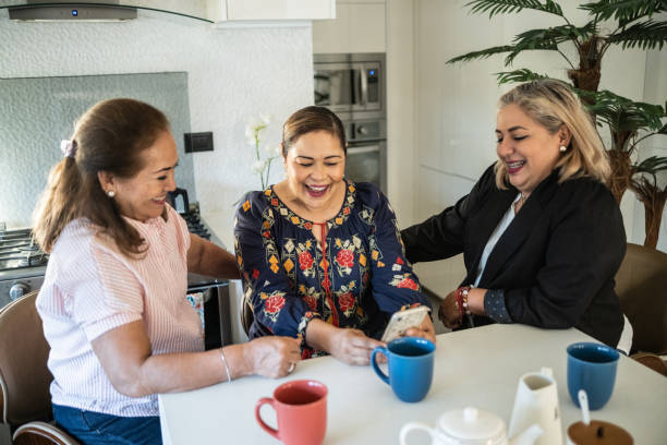 istock Female Latin friends using a mobile phone at home 1371362970