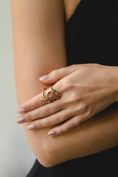 金の指輪を身に着けている女性の手のクローズアップ - ネイルアート 写真 ストックフォトと画像