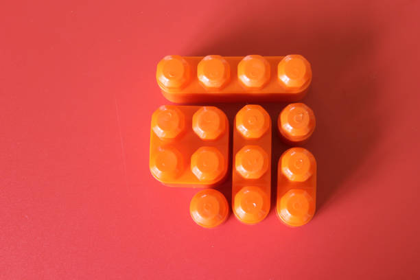 blocks to play, build and organize on a red background as a concept of inclusion, diversity and plurality it lacks a member, a piece to complete