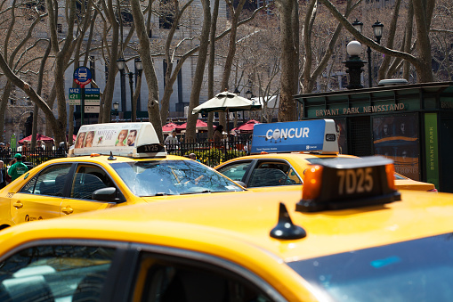 New York City, United States - April 16, 2016: View of 42nd street with cabs driving along Bryant Park