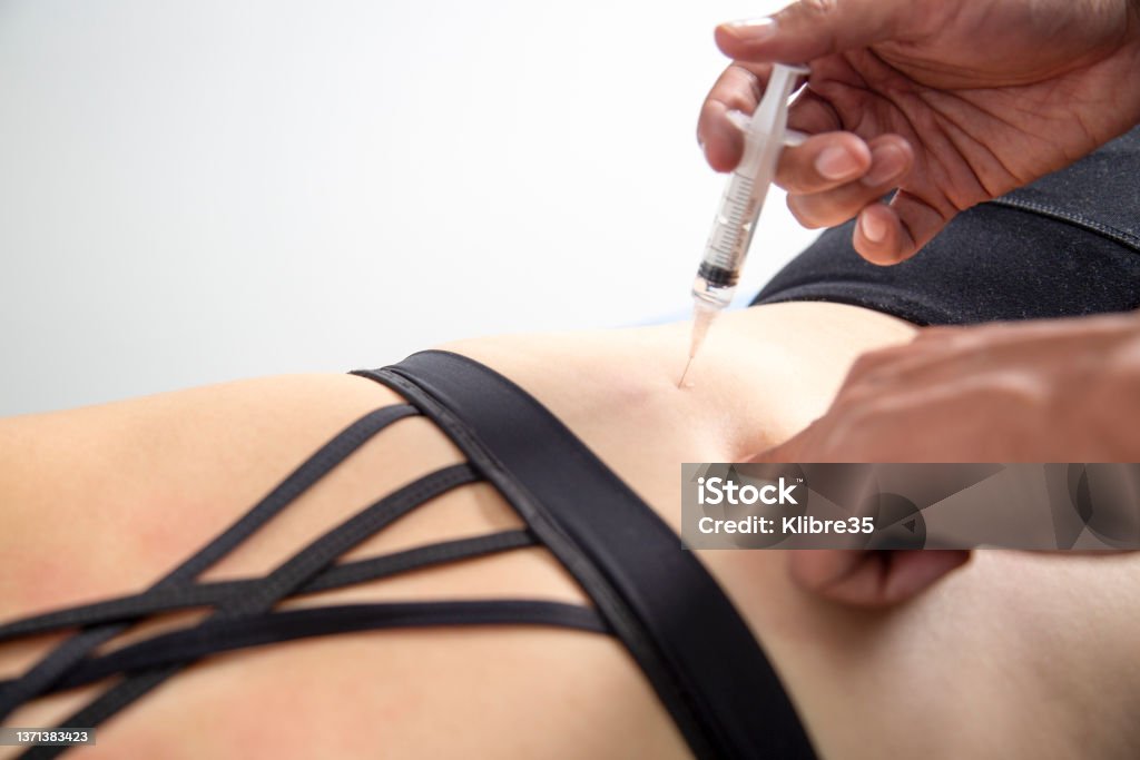 The doctor injects trigger points in the girl's back The doctor injects trigger points in the girl's back, alternative medicine treatment to heal back pain. Injecting Stock Photo