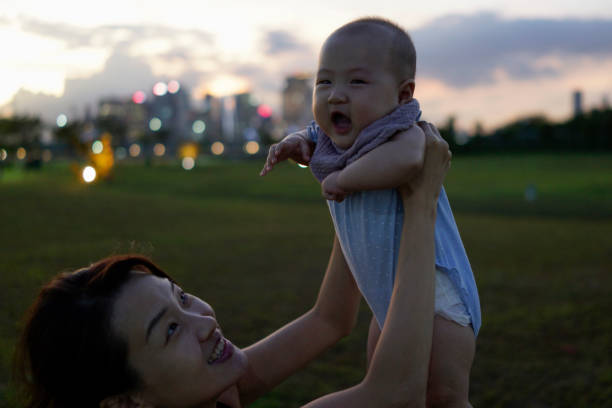 Asian mum bonding with baby at dusk