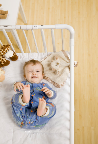 Toddler boy unhappy about taking a nap in crib in bedroom