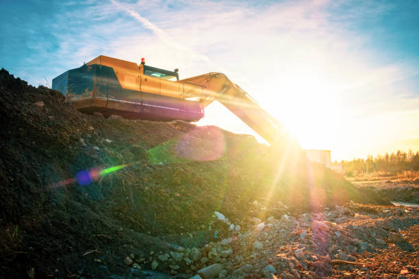 istock Yellow excavator on a road construction at sunset. 1371391868
