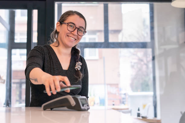 istock Woman making contactless payment with smartphone at cafe 1371393263