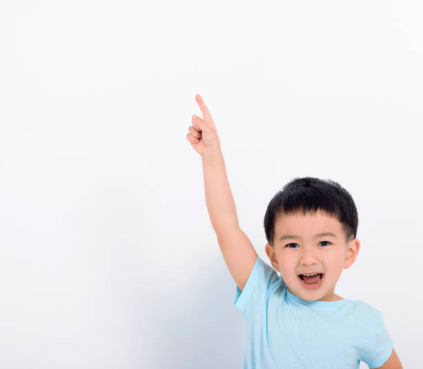 istock Happy little boy pointing to copy space 1371396772