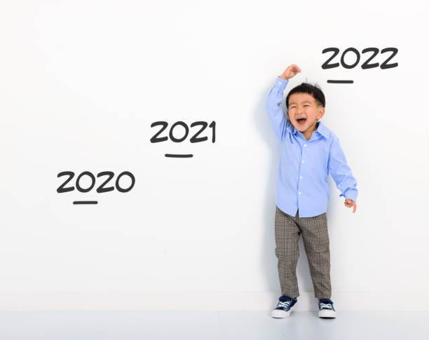 Happy Little boy measuring height at home stock photo