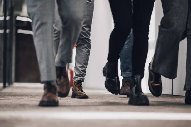 istock Group of coworkers walking together in shared office space hallway 1371402721