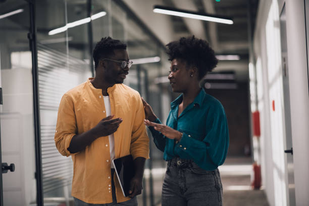 istock Two millennial coworkers talking and smiling in their start-up office. 1371405567