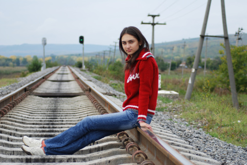Young girl sitting on railway