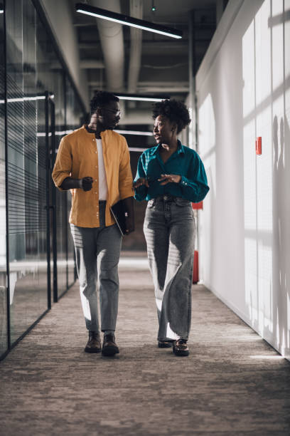 istock Two confident young African-American colleagues discussing work in office hallway 1371405651