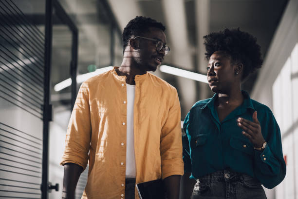 istock Two confident black businesspersons having a casual chat in office hallway 1371406437